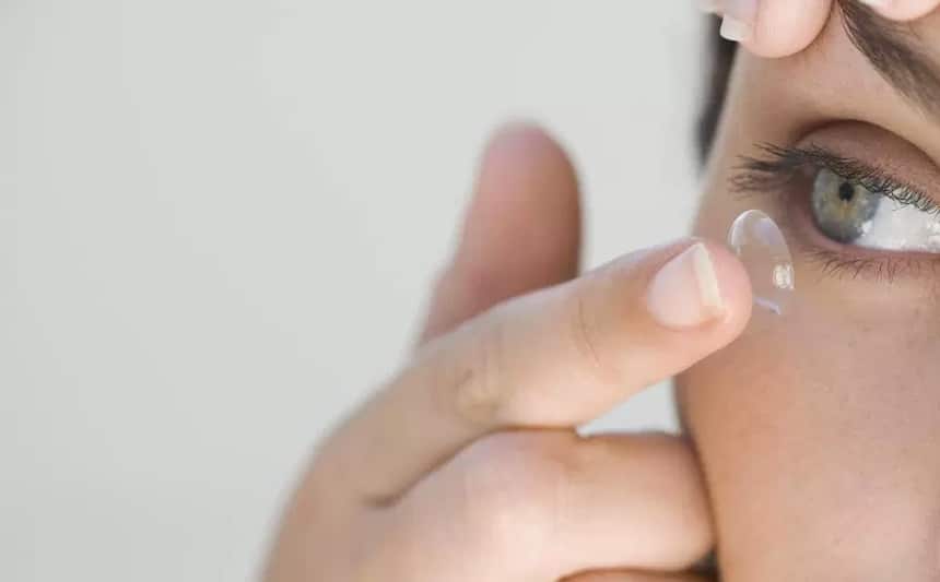 woman inserts lens